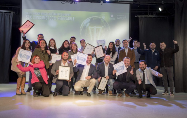 Diverse group of people on a stage posing with certificates and awards during an achievement ceremony.